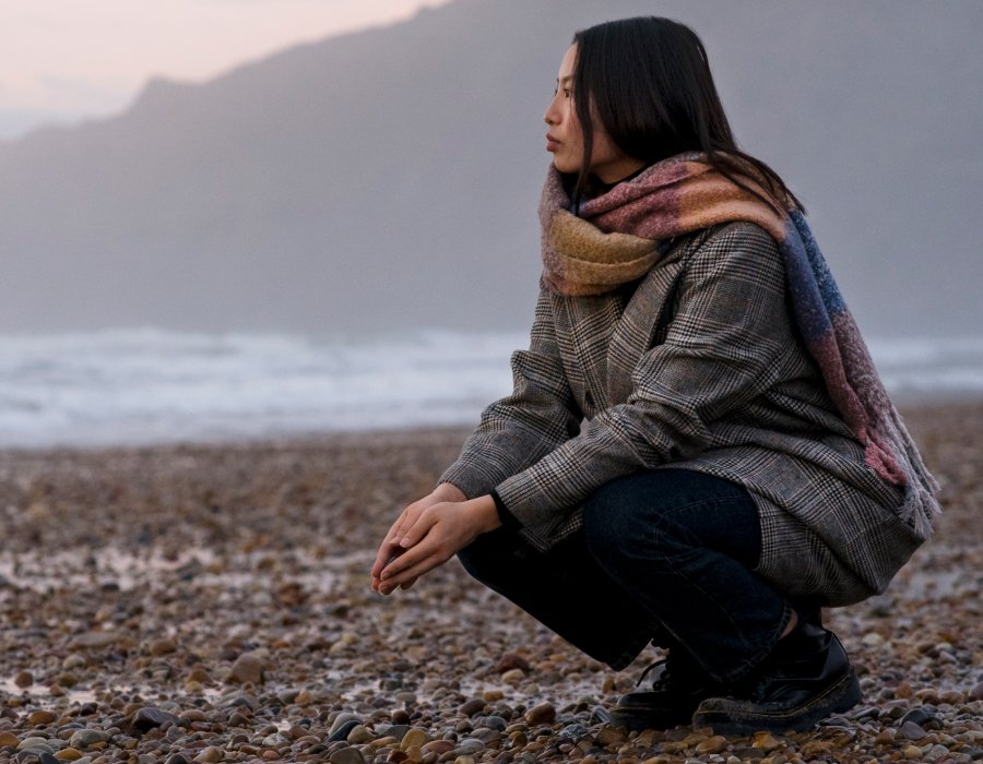 Mujer reflexionando frente al mar